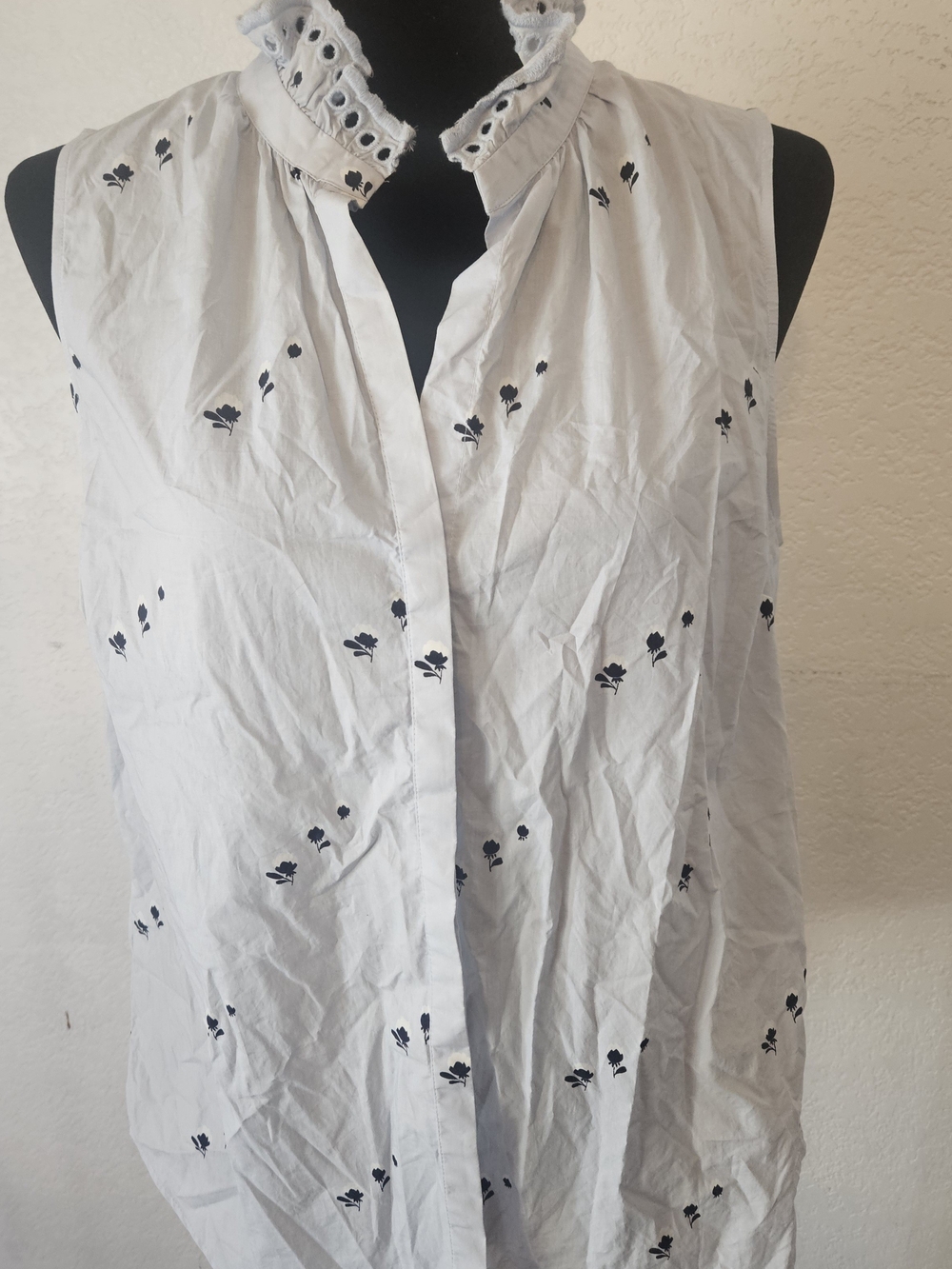 This is an Ann Taylor sleeveless button-front top featuring a floral print